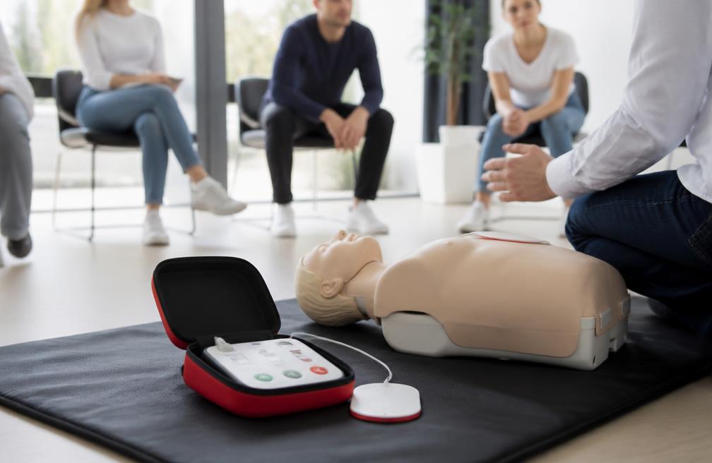 AED-Trainer und Reanimationspuppe in einem hellen Kursraum